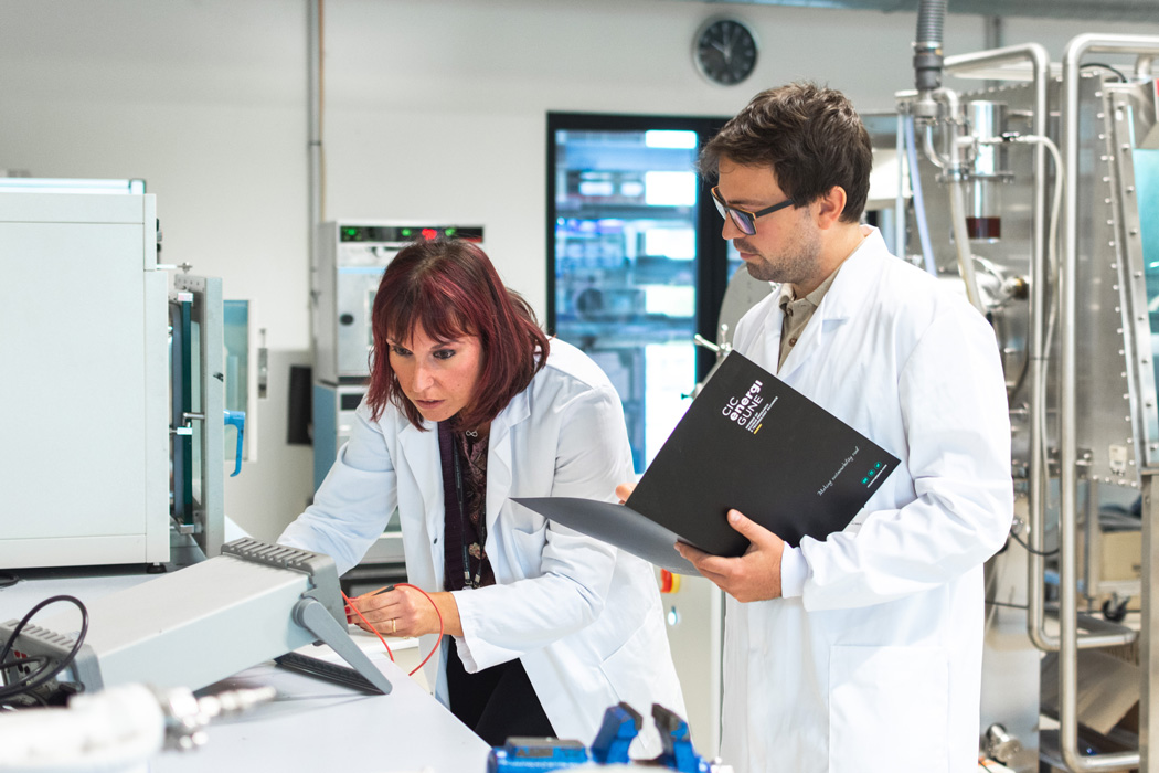 Two researchers from CIC energiGUNE involved in the project work in the laboratory of the basque research center. Whilst one is having a look at the results displayed, the other is taking note on a CIC energiGUNE´s notebook.